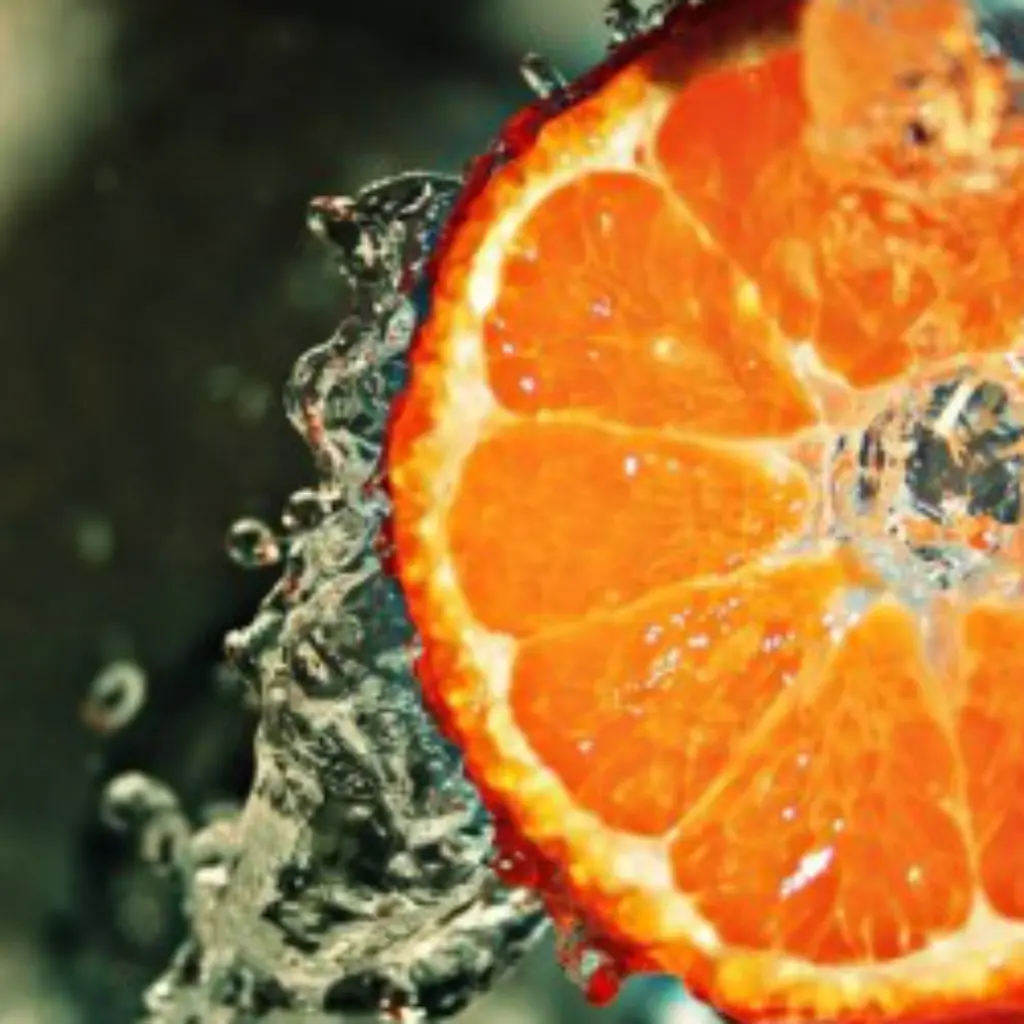 Eine Orangenscheibe umgeben von Wassertropfen