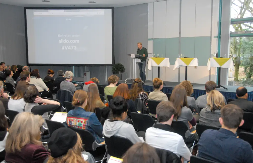 Ulrich Post hält Vortrag am Rednerpult in Plenum // Bild: Erik-Holm Langhof