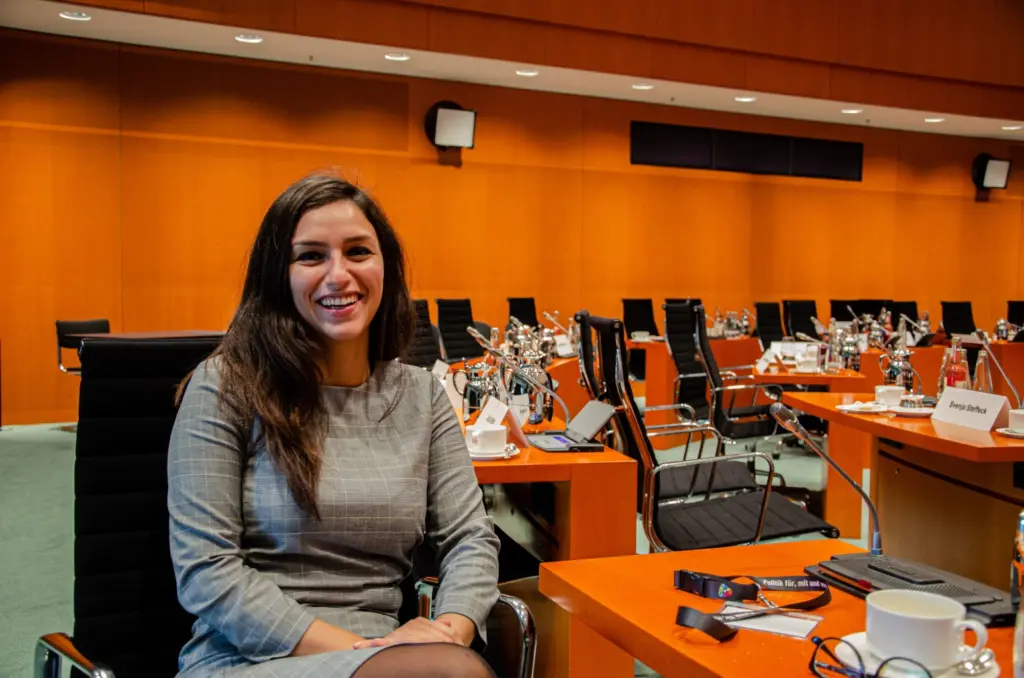 Teilnehmerin sitzt im Konferenzraum des Bundeskanzleramtes