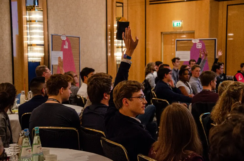 Junge Menschen sitzen in einem Raum und diskutieren.