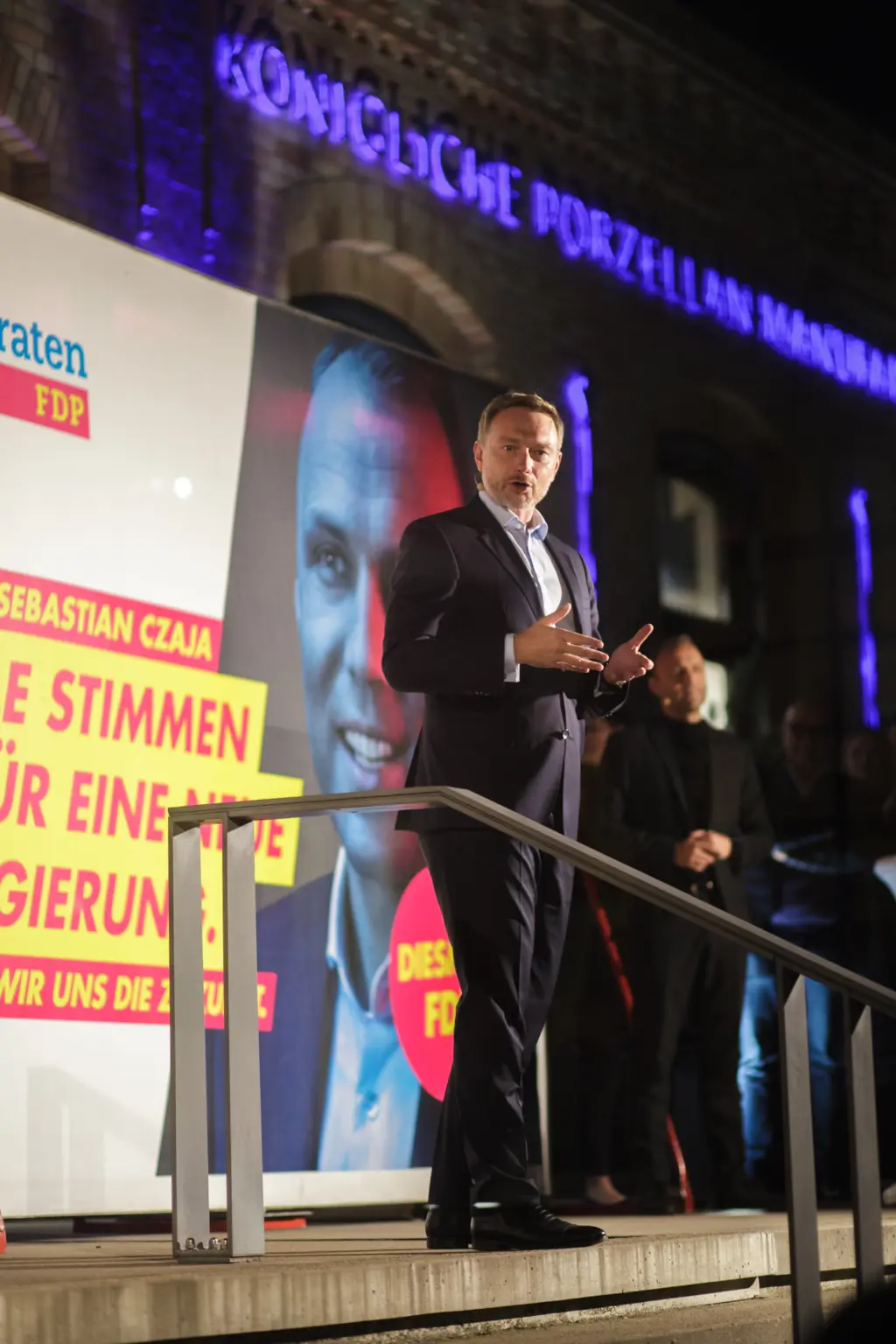 Christian Lindner steht auf der Bühne vor einem großen Wahlplakat und hält eine Rede.