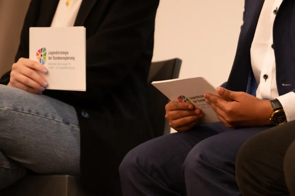 Zwei Menschen mit Moderationskarten mit der Aufschrift Jugendstrategie.