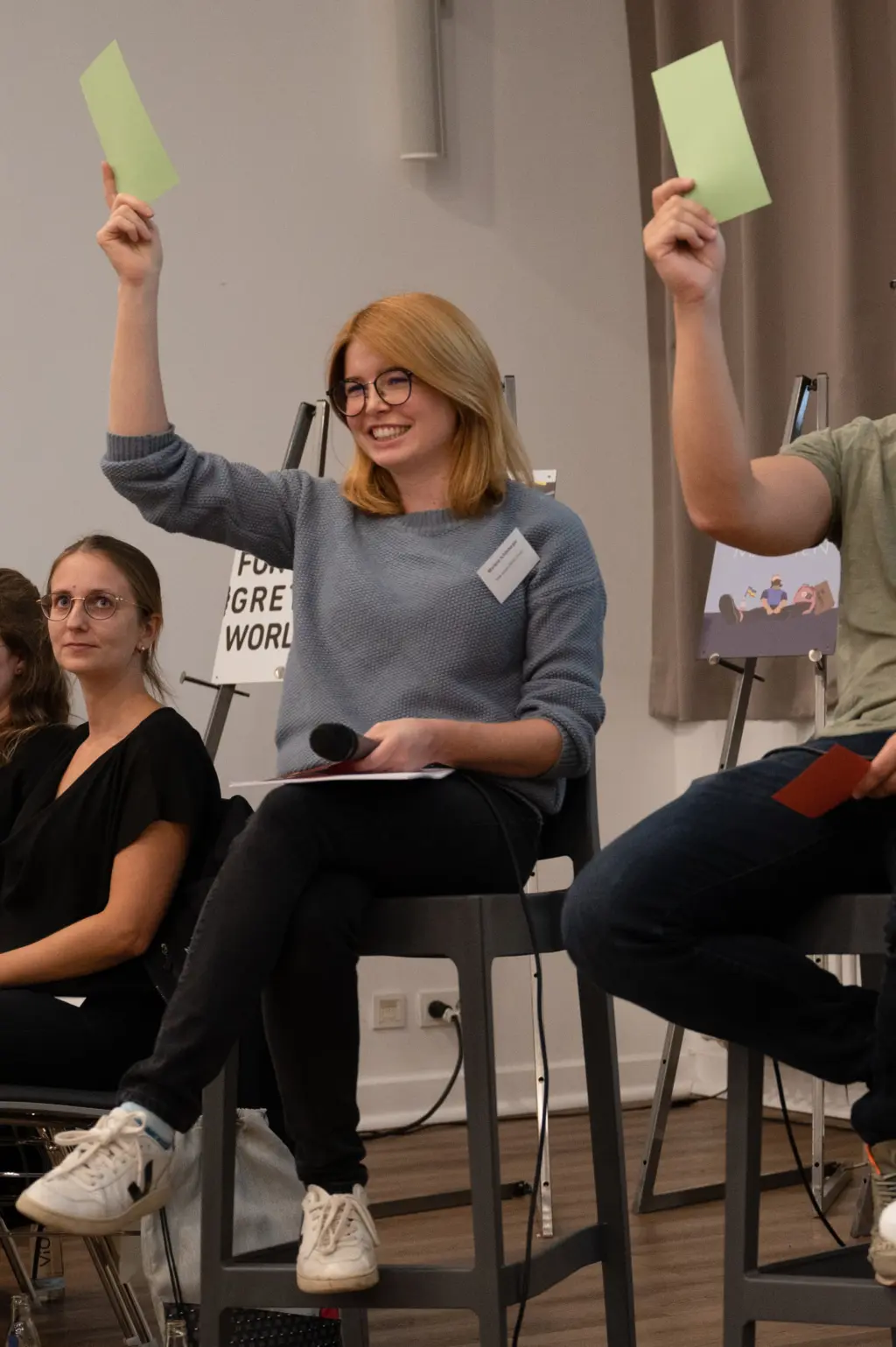 Politikerin Melanie Schönberger hält einen grünen Zettel hoch.